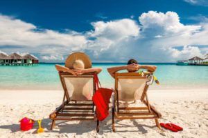 couple-in-loungers-on-beach-at-maldives