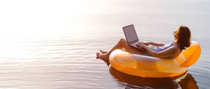 business-woman-working-on-a-laptop-in-an-inflatable-ring-in-the-water